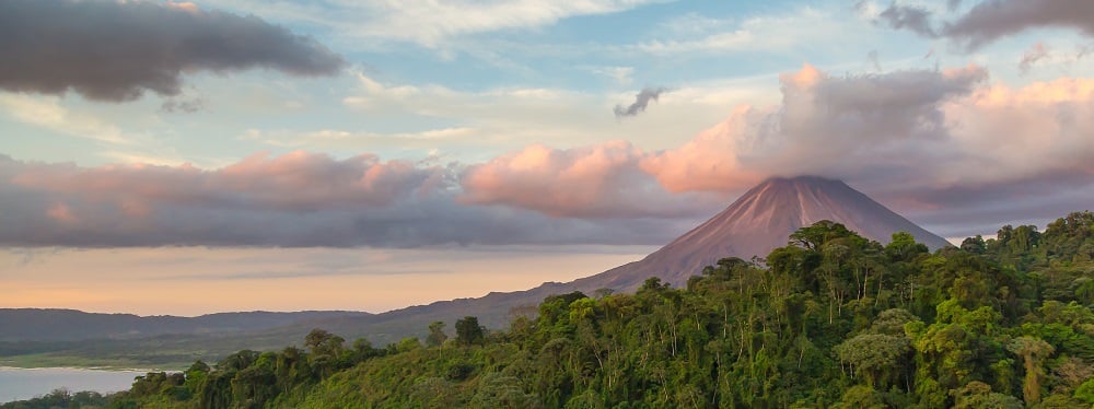 Arenal Volcano at Sunrise in Costa Rica, as the sun reflects on the newly formed clouds