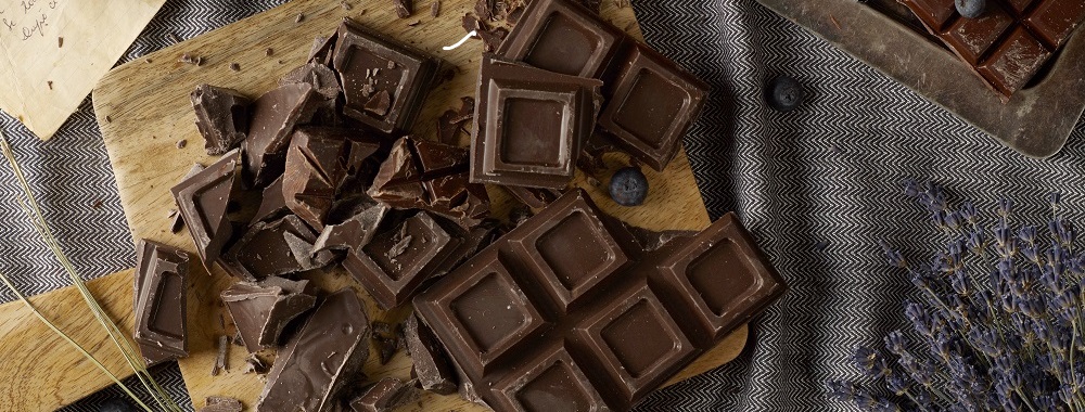 Dark chocolate on trencher and coffee beans