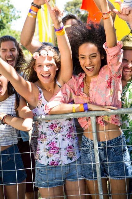 Excited music fans up the front at festival on a summers day