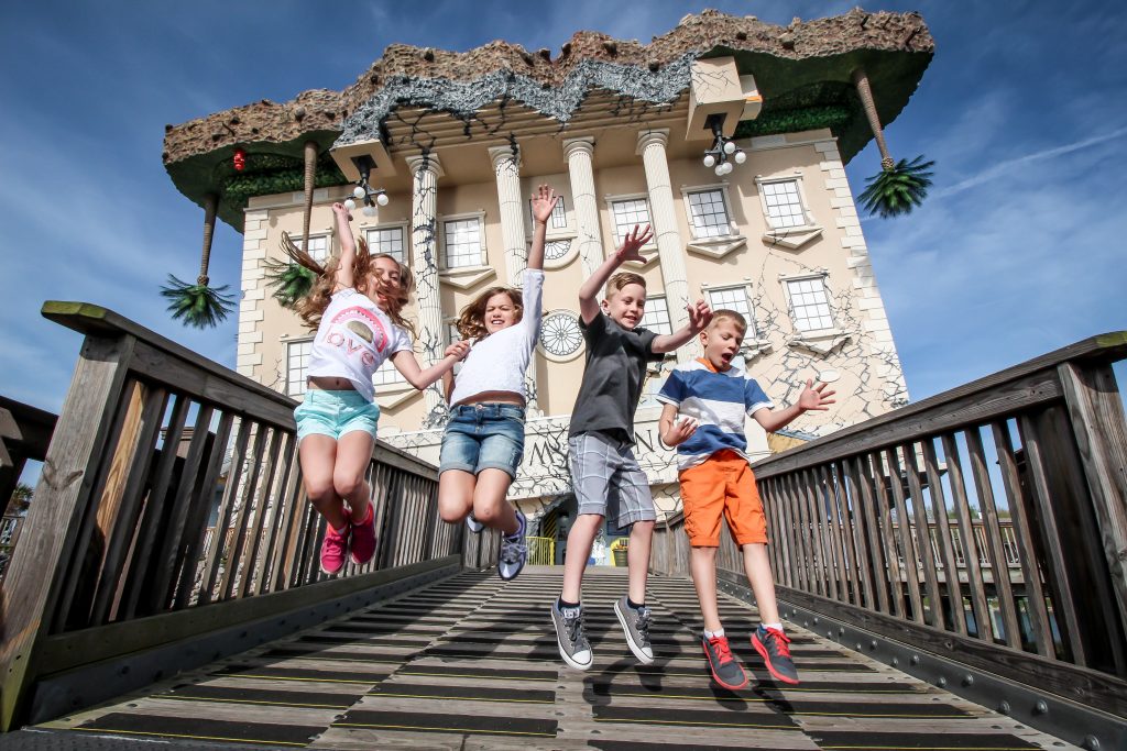 Kids jumping in front of upside down Wonderworks building Credit WonderWorks