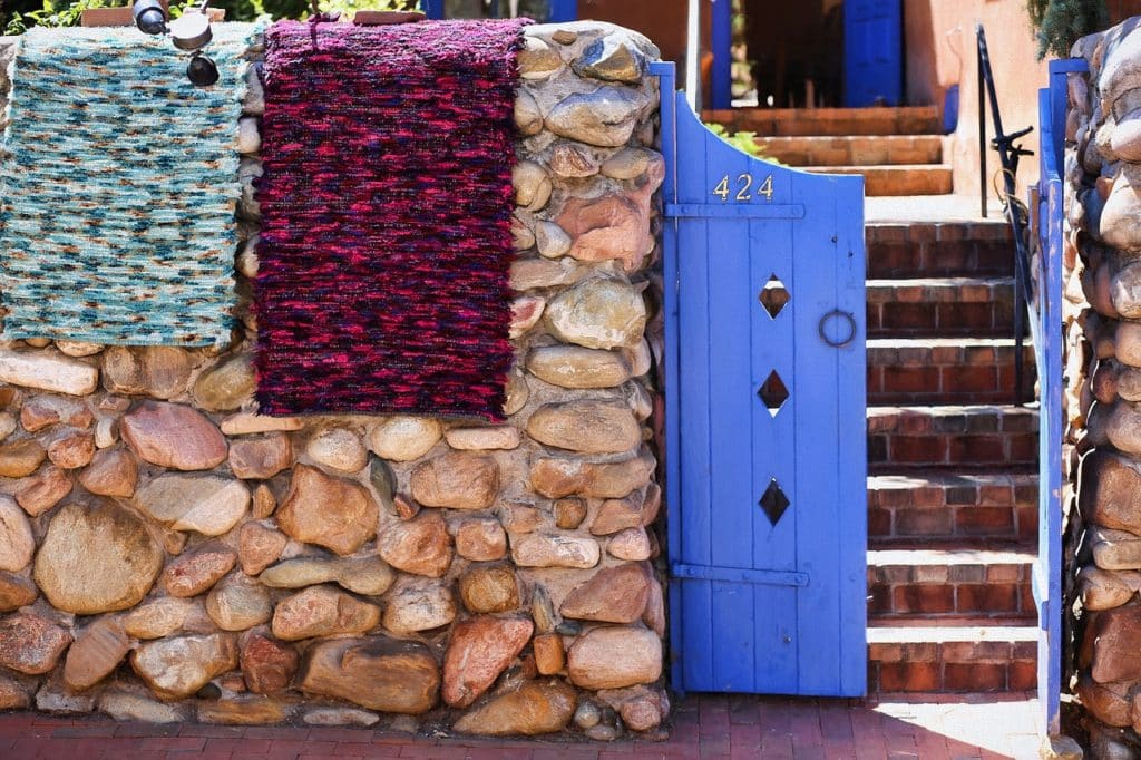 Stone wall with blankets over the top with bright purple gate
