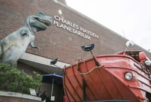 Charles Hayden Planetarium exterior with T-Rex statue and Commonwealth Curley red boat
