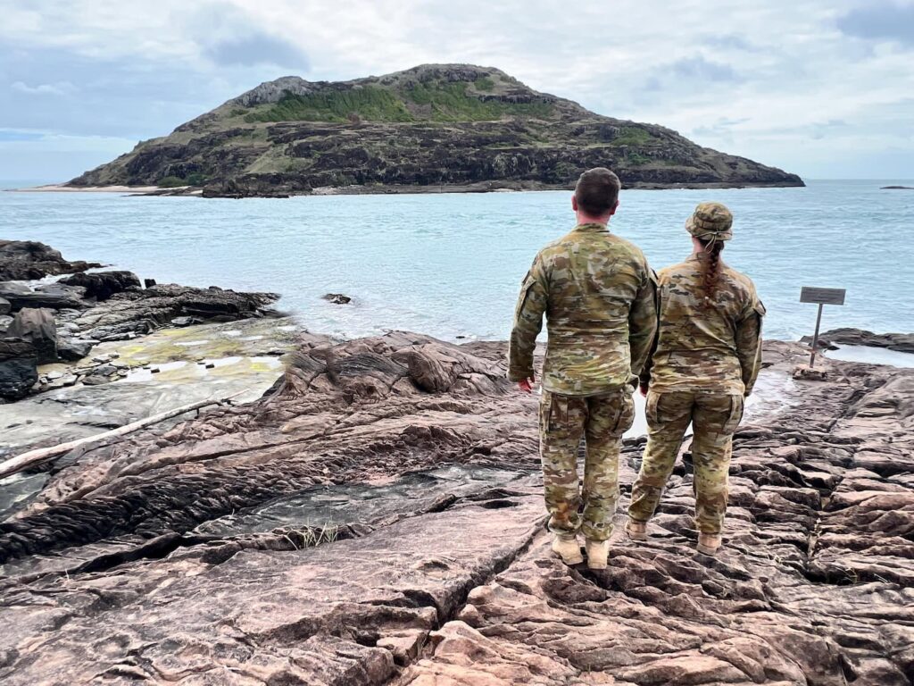 Army soldiers standing on rocky beach