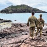 Army soldiers standing on rocky beach